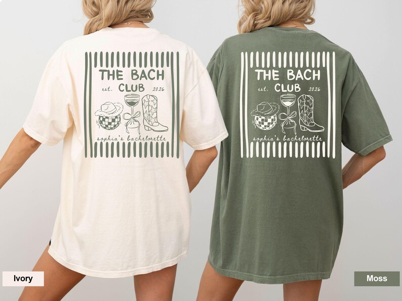 May include: Two short-sleeved t-shirts, one ivory and one moss green, feature a graphic design on the back. The design includes the text "THE BACH CLUB est. 2026" within a rectangular frame, along with illustrations of a cowboy hat, a disco ball, a wine glass, and a cowboy boot. The text "sophia's bachelorette" is also included.