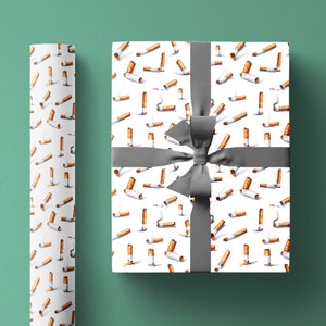 Op de afbeelding: Wit cadeaupapier met een herhalend patroon van aquarel sigaretten. Het cadeaupapier is vastgebonden met een grijs lint.