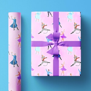 Puede incluir: Papel de regalo rosa con un patrón repetido de bailarines y un gato disfrazado. El papel está atado con una cinta morada.