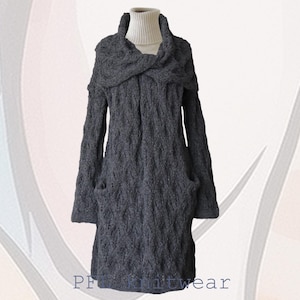 Könnte beinhalten: Ein langer, grauer Strickcardigan mit einem großen, gefalteten Kragen und Taschen. Der Cardigan ist aus einem weichen, strukturierten Garn gefertigt.