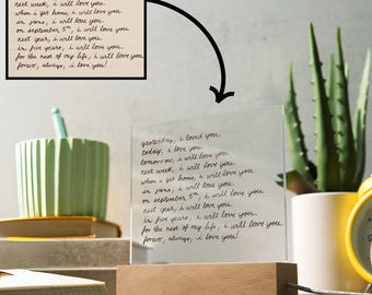 May include: A clear glass frame with a wooden base, displaying a handwritten message that reads "yesterday, I loved you. today, I love you. tomorrow, I will love you. next week, I will love you. when I get home, I will love you. in June, I will love you. on September 5th, I will love you. next year, I will love you. in five years, I will love you. for the rest of my life, I will love you. forever, always, I love you!"