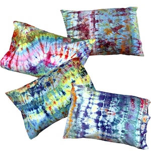 May include: Four rectangular pillowcases featuring vibrant tie-dye patterns in various color combinations including blue, purple, yellow, red, and green. Each pillowcase displays a unique, swirling, and striped design created with saturated fabric dyes.