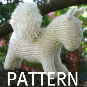 May include: A white knitted stuffed animal resembling a dog or a horse with a fluffy tail. The animal is standing on a tree branch. The word "PATTERN" is printed in white letters on the bottom of the image.