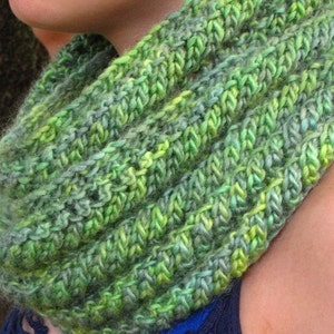 May include: A green and blue knitted infinity scarf with a soft, fuzzy texture.