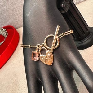 Bracciale Ralph Lauren Originale con Ciondoli, Bracciale a Catena Paperclip Dorato, Chiusura a T con Cuore a Lucchetto e Gemma Rosa, Regalo