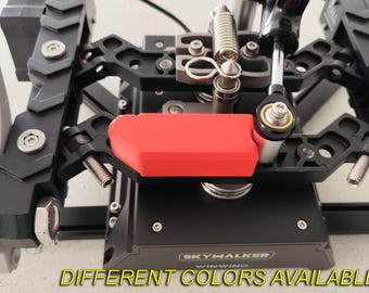 May include: A detailed view of a black and silver mechanical assembly, featuring a prominent red element. The device incorporates various metal components such as springs, bolts, and a control arm. The text "DIFFERENT COLORS AVAILABLE" is visible at the bottom.