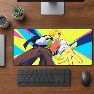 May include: A rectangular desk mat featuring a vibrant anime-style illustration of a character with spiky blonde hair, wearing a white shirt, red vest, and dark jacket, reaching forward against a background of bright yellow, cyan, and magenta rays.