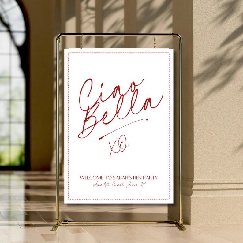 May include: A white sign with a red border and red text that says "Ciao Bella" with an "XO" underneath. The sign also says "Welcome to Sarah's Hen Party Amalfi Coast June 21st".