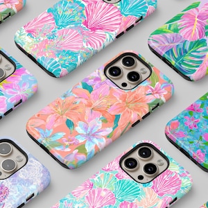 May include: A collection of colorful phone cases with vibrant floral and tropical leaf patterns. Designs include pink, orange, and blue flowers, as well as green leaves and seashell motifs. The cases have a black border.