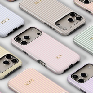 May include: A selection of pastel-coloured phone cases with vertical stripes. Each case displays a different hue, such as pink, yellow, and lavender. Gold initials are printed on each case. The cases are designed to fit a smartphone.