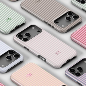 May include: An array of personalized phone cases with a striped pattern in various pastel colors, including pink, blue, green, and beige. Each case features a unique set of initials in a matching color. The cases are arranged on a white surface.