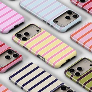Puede incluir: Una colección de fundas para teléfonos con diseños de rayas horizontales. Las fundas presentan varias combinaciones de colores, incluyendo rosa, rojo, azul, amarillo y verde. Las fundas están diseñadas para adaptarse a un smartphone y tienen recortes para la cámara y los botones.