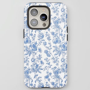 May include: A white phone case with a blue floral pattern. The design features detailed illustrations of flowers and foliage, creating a classic, elegant look. The case has a glossy finish and a protective design.