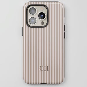 May include: A phone case with a vertical striped pattern in beige and light brown. The case has a glossy finish and features the initials "CH" in a darker brown font. The camera module is visible at the top.