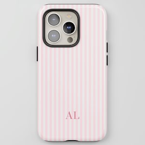 May include: A pink and white striped phone case with the initials "AL" in a matching pink font. The case has a black border around the camera and sides. The phone case is designed to fit a smartphone.