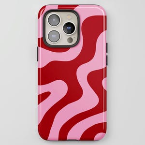May include: A phone case with a glossy finish, displaying an abstract pattern of flowing lines. The design features red and light pink wavy shapes. The phone case has a black border and camera housing.