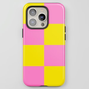 May include: A smartphone case with a vibrant checkerboard pattern in pink and yellow. The case has a glossy finish and a black camera housing. The phone case is designed to fit a modern smartphone.
