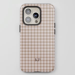 May include: A phone case with a tan and white gingham pattern. The case has a glossy finish and features a camera cutout and black side buttons. The initials "KP" are printed in a dark brown color on the lower center of the case.