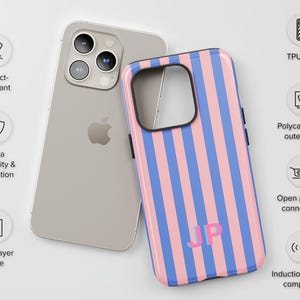 May include: A dual-layer phone case featuring vertical pink and blue stripes with the monogram JP in pink. The case includes a polycarbonate outer shell, a TPU liner, open ports for connectivity, and is impact-resistant and induction charger compatible.