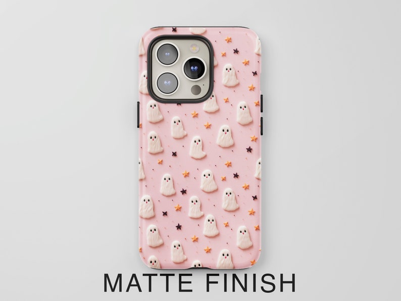 May include: A pink phone case with a pattern of white ghosts and orange stars. The case has a matte finish.