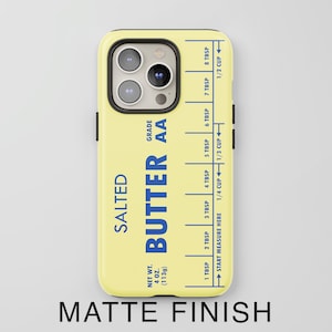 May include: A yellow phone case with a butter stick design. The case has a blue label that says "SALTED BUTTER AA" and includes a measurement guide in tablespoons and cups. The case has a matte finish.