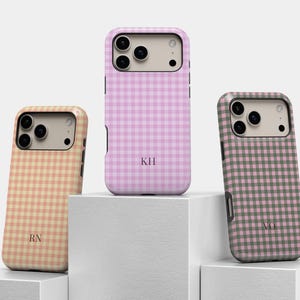 Puede incluir: Tres fundas para smartphone con un patr&oacute;n de cuadros vichy en color melocot&oacute;n, rosa claro y verde salvia. Cada funda tiene una zona beige para la c&aacute;mara y est&aacute; personalizada con iniciales de dos letras en fuente serif: RN, KH y VO.
