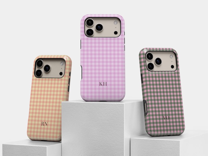 Puede incluir: Tres fundas para smartphone con un patr&oacute;n de cuadros vichy en color melocot&oacute;n, rosa claro y verde salvia. Cada funda tiene una zona beige para la c&aacute;mara y est&aacute; personalizada con iniciales de dos letras en fuente serif: RN, KH y VO.