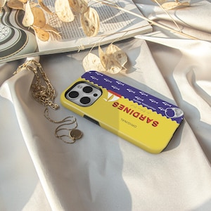 May include: A yellow phone case with a blue and white sardine can design. The can says "ORIGINAL" and "SARDINES" in a retro font. The case has a cutout for the phone camera.