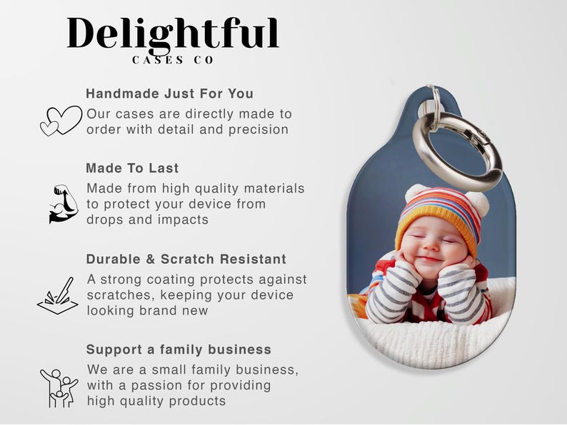 May include: A phone grip with a photo of a smiling baby wearing a striped hat and mittens. The grip has a silver ring and is attached to a blue and white oval-shaped case. The text "Delightful CASES CO" is at the top.