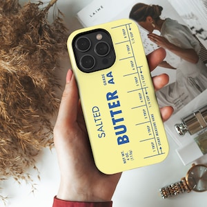 May include: A yellow phone case with a stick of butter design. The case has a blue label that reads "Salted Butter AA" and includes a measurement guide in tablespoons and cups. The case is 4 oz (113g).