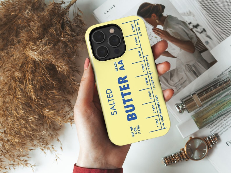May include: A yellow phone case with a stick of butter design. The case has a blue label that reads "Salted Butter AA" and includes a measurement guide in tablespoons and cups. The case is 4 oz (113g).