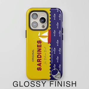 May include: A yellow and blue phone case with a design of a can of sardines. The can has the text "ORIGINAL SARDINES In Olive Oil TRADITIONAL RECIPE". The phone case has a glossy finish.