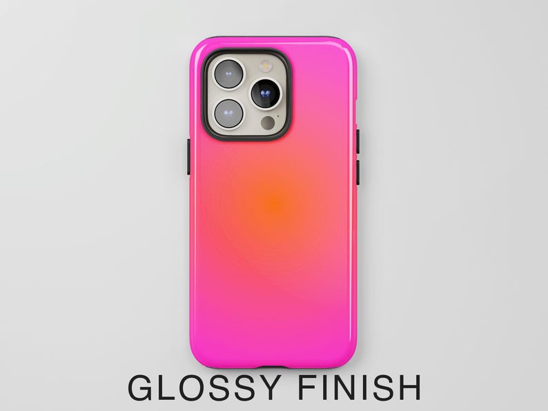 May include: A glossy phone case with a gradient design, transitioning from bright pink to orange. The case has a black border and features the camera module. The text "GLOSSY FINISH" is at the bottom.