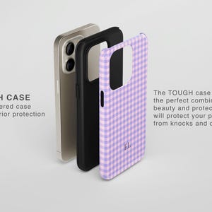Puede incluir: Una funda de tel&eacute;fono de doble capa con un patr&oacute;n de cuadros vichy en color lila claro y blanco, con las iniciales EL impresas en la parte posterior. Se muestra junto a un forro negro y un smartphone dorado. Texto: TOUGH CASE Dual layered case.