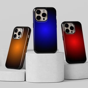 May include: Three smartphone cases with a gradient design. One case has an orange to brown gradient, another has a blue to black gradient, and the third has a red to black gradient. The cases are on white pedestals.
