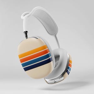 May include: White over-ear headphones with a cream-colored ear cup featuring horizontal stripes in orange, yellow, blue, and navy. The headphones have a white headband and ear cushions, and a silver metal accent.