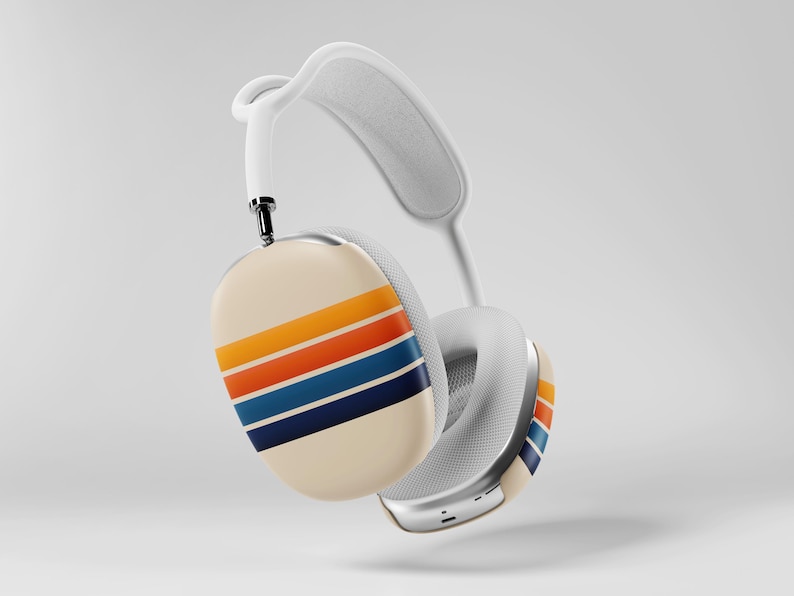 May include: White over-ear headphones with a cream-colored ear cup featuring horizontal stripes in orange, yellow, blue, and navy. The headphones have a white headband and ear cushions, and a silver metal accent.