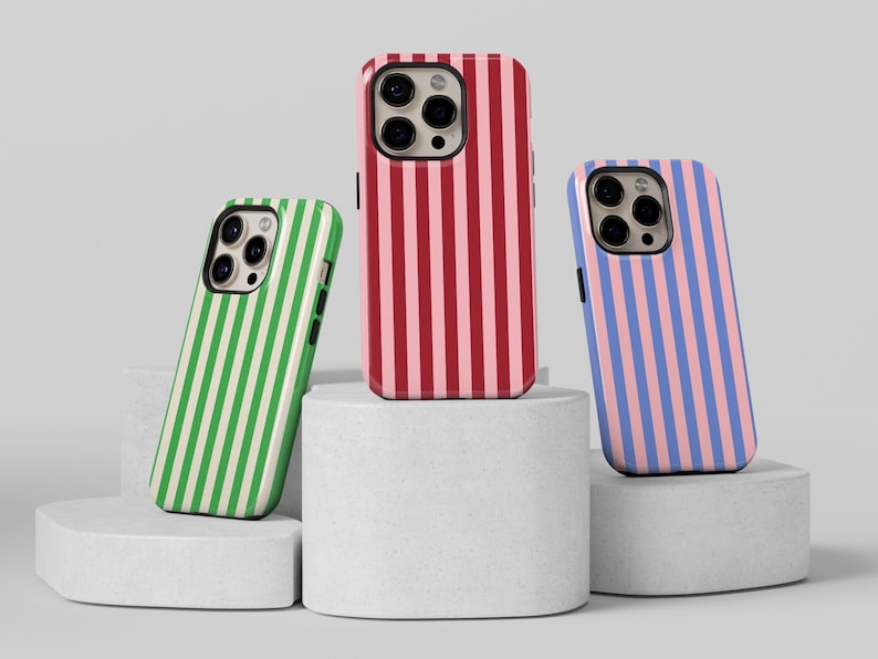 May include: Three phone cases with different striped patterns. The cases are red and pink, green and white, and blue and pink.