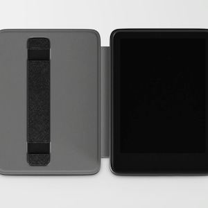 May include: A gray tablet case with a black hand strap is open next to a black tablet. The case is rectangular and has a textured surface. The tablet has a black screen and a black border.