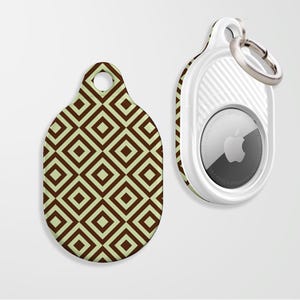 May include: An Apple AirTag with a white case and a silver key ring next to a matching tag with a brown and light green geometric pattern. The AirTag has the Apple logo on the front.