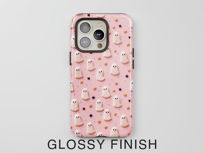 May include: Pink phone case with a pattern of white ghosts and orange stars. The case has a glossy finish.