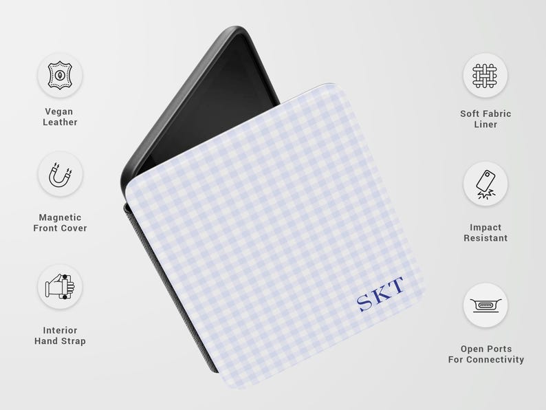 May include: A phone case with a light blue and white gingham pattern. The case has a black interior and features the initials "SKT" in navy blue. Additional features include vegan leather, a magnetic front cover, and an interior hand strap.