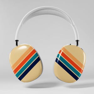 May include: Cream-colored over-ear headphones with a white headband. The earcups feature a retro design with diagonal stripes in orange, red, teal, and navy blue. The headphones are suspended in the air against a plain background.
