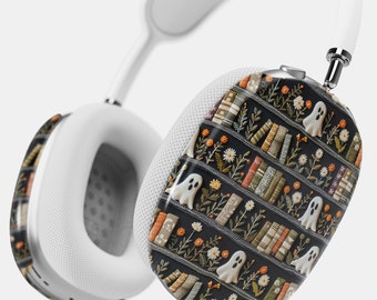 May include: White wireless headphones with a black and white patterned design featuring a bookshelf with books and ghosts. The pattern is a repeating design of a bookshelf with books and ghosts.