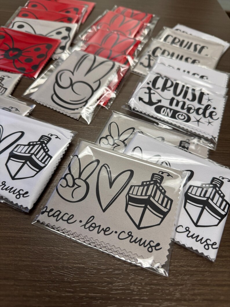 May include: A variety of microfiber cleaning cloths with different designs. The cloths feature peace signs, hearts, cruise ships, and the text "Peace. Love. Cruise" and "Cruise Mode On".