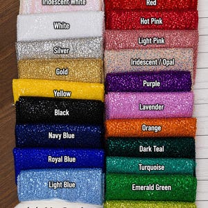 Puede incluir: Una colecci&oacute;n de muestras de tela rectangulares con una textura brillante de lentejuelas dispuestas en dos columnas. Los colores incluyen granate, rojo, rosa fuerte, rosa claro, iridiscente, morado, lavanda, naranja, verde azulado oscuro, turquesa, verde esmeralda, verde lima, blanco iridiscente, blanco, plata, oro, amarillo, negro, azul marino, azul real y azul claro. El texto Hill Girls DESIGNS est&aacute; en la parte inferior.