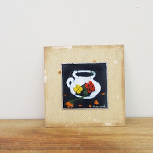 May include: A framed painting of a white ceramic pitcher with a red and yellow flower arrangement on a black background. The painting is signed "K.P. Smith".