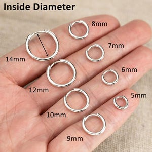 May include: A variety of silver hoop earrings in different sizes, ranging from 5mm to 14mm in diameter, are displayed on a hand. The text "Inside Diameter" is at the top of the image, with measurements clearly labeled next to each earring.