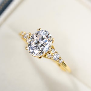 May include: A gold ring with a large oval-shaped diamond and smaller diamonds set in the band.