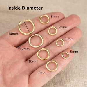 May include: A collection of gold-toned hoop earrings in various sizes, labelled with their inside diameters ranging from 5mm to 14mm. The text Inside Diameter is visible at the top, and a black arrow indicates the measurement path on one hoop.